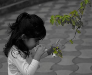 A_curious_child,_smelling_flower,_India